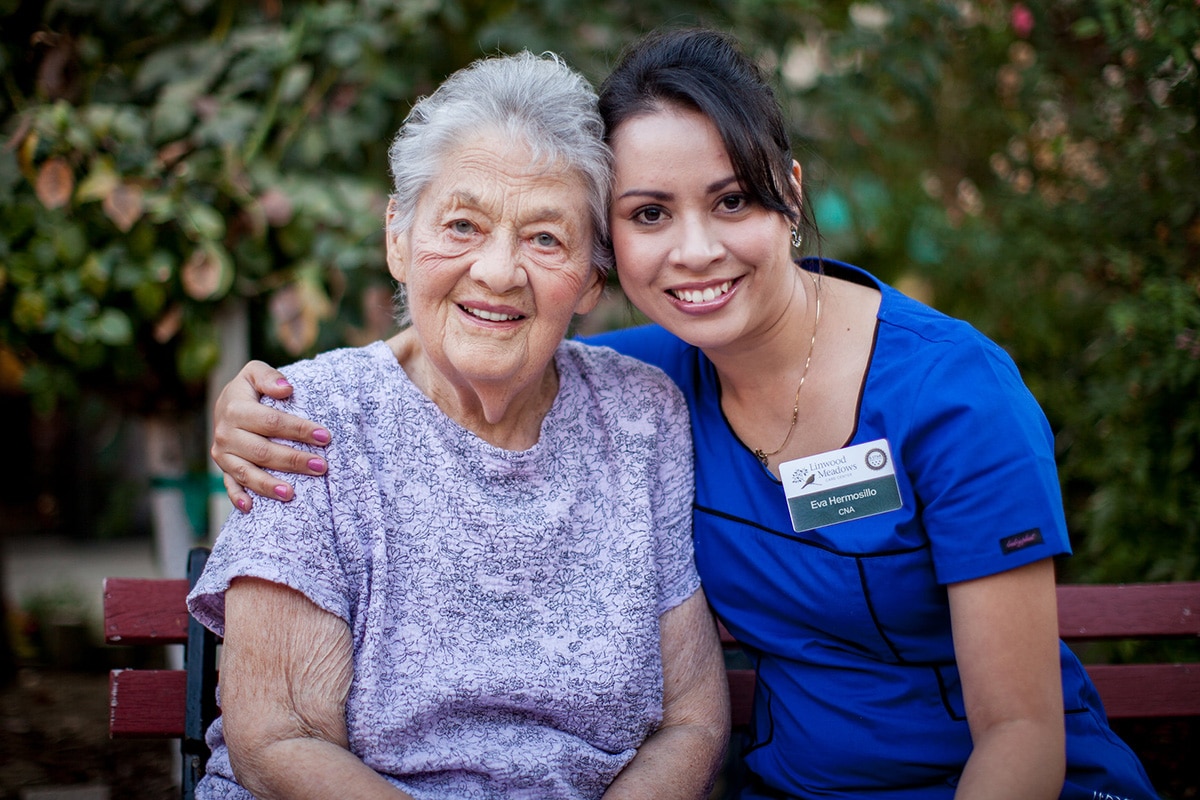 CNA nurse smiling with a resident