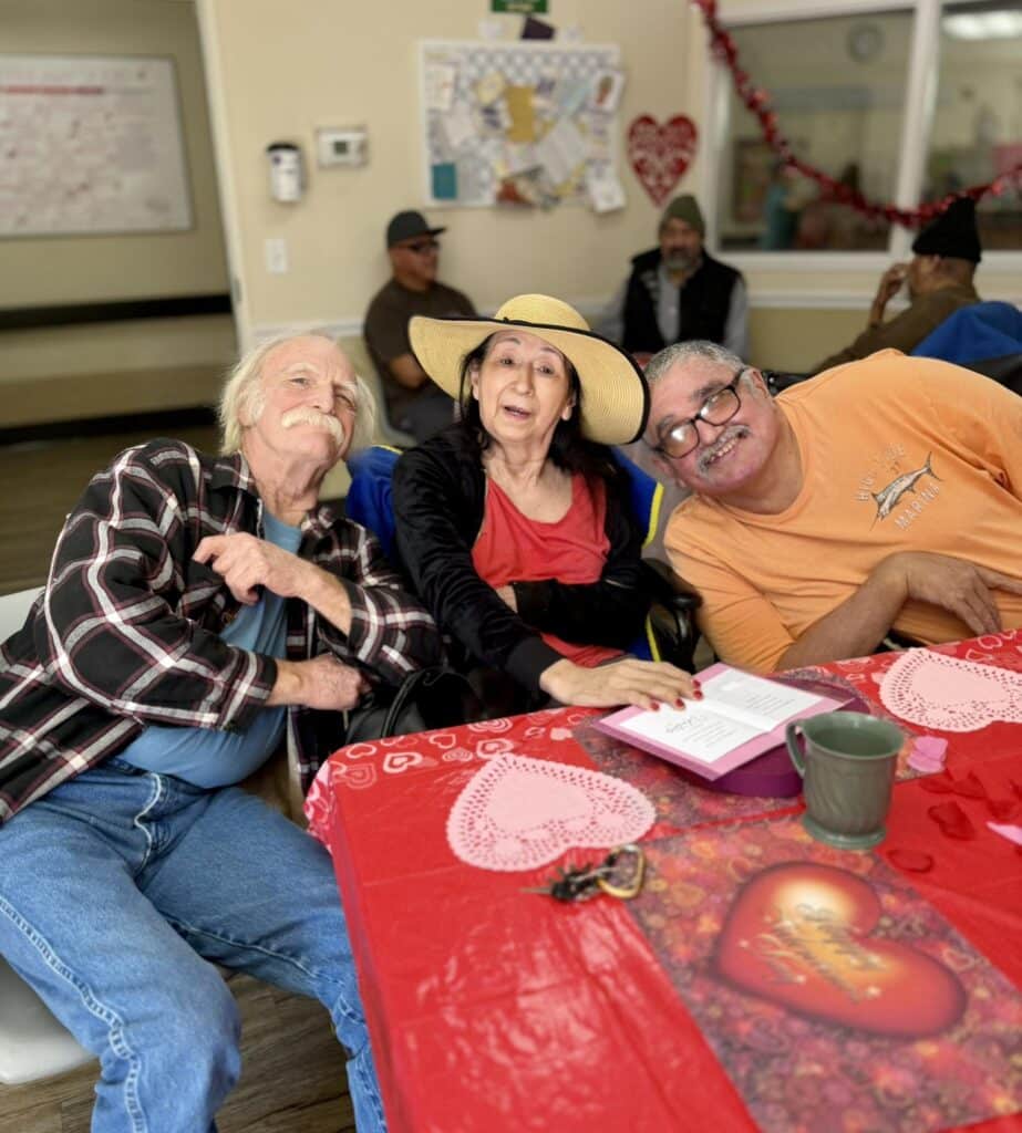 3 people sitting together at a table during linwood meadows valentines day lunch